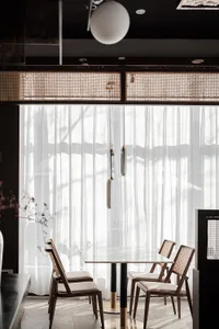 A minimalist interior space featuring glass, wood, and fabric elements.