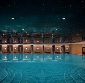 Swimming pool interior with glass tiles and concrete ceiling
