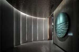 Modern interior featuring textured concrete panels and metallic ampelite elements.