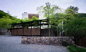 A modern landscape design featuring stone walls and a gravel path.