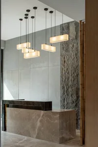 A modern lobby with concrete walls and a reception desk made of the same material, featuring a minimalist design with hanging