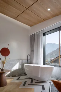 A modern minimalist bathroom with a freestanding bathtub, marble and glass accents, and a wooden ceiling.
