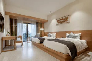 A modern residential bedroom with a wooden floor and furniture.
