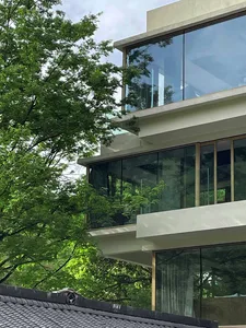 Modern residential exterior featuring glass, concrete, and metal materials.