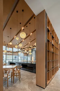 A modern restaurant facility with wooden furnishings, illuminated by spherical light fixtures.