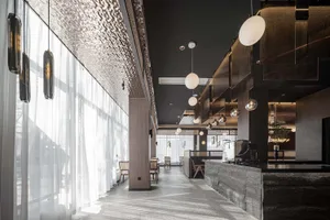 Modern restaurant interior featuring glass, metal, and wood materials.