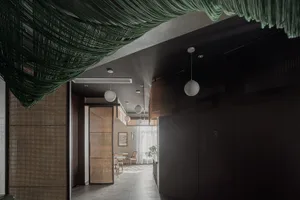 Contemporary restaurant interior with greenery accent and wooden decorative panels.