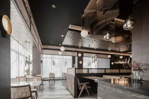 A modern restaurant interior featuring a textured metallic ceiling and glass chandelier fixtures.