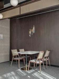 A modern dining room with wooden chairs and marble table