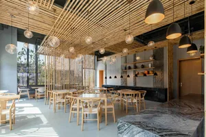 A modern restaurant interior with a wooden ceiling and seating area.