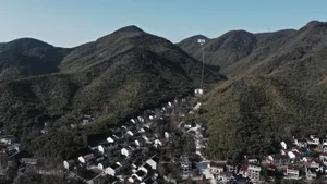 A beautiful aerial view of a mountain village with a lake house nestled among the trees.