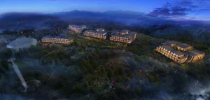 View of a residential hotel resort complex at night with illuminated exterior features and lights.