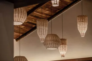 Multiple woven lighting lamps hanging indoors