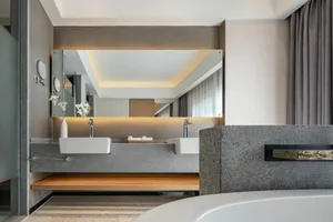 Modern bathroom with a granite countertop and double sinks.