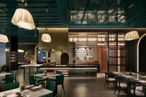 Modern industrial restaurant interior with metal ceiling, brick walls, and ceramic tile flooring.