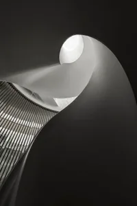 A minimalist design featuring a white concrete staircase with sleek, curved steps leading upwards.