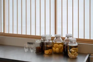 Multiple glass jars containing preserved fruits and nuts on a counter.