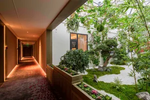 An interior space featuring a green roof garden with concrete structures and lush green vegetation.