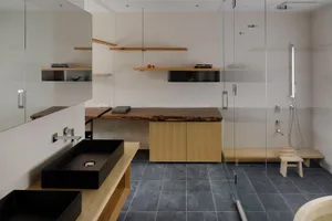 Minimalist bathroom featuring concrete, glass, and wood elements.