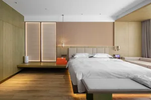 A minimalist modern bedroom featuring sleek design elements, white bedding, and wooden flooring.