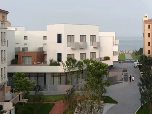 Modern apartment building with concrete and wood exterior and large windows.