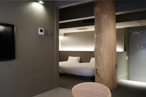 A modern bedroom featuring concrete walls and wooden accents.
