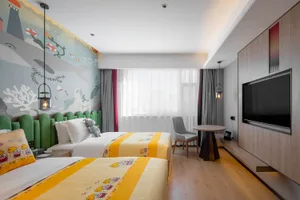 Modern residential bedroom with two beds featuring yellow bedspreads adorned with cute woodland animal prints, an underwater-