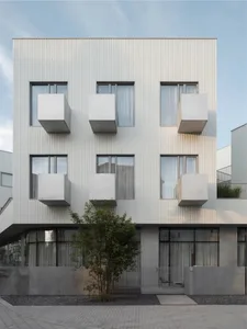 Modern building exterior with concrete walls and large windows.