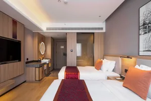 Modern hotel room featuring wooden furniture with minimalist decor.