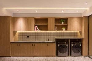 Well-organized laundry room with modern wooden cabinets and storage solutions.