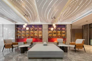 Modern lobby with a wooden structure and stone seating area.