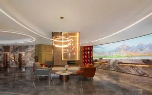 Modern lobby with marble flooring and seating areas.