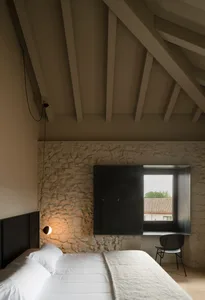 A modern minimalist bedroom with a bed, lamp, chair, and minimalist style