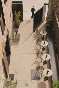 A modern restaurant with concrete exterior and pottery planters.