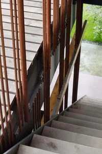 An industrial-style staircase featuring wooden steps and steel railing.