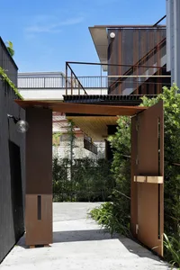 A modern entryway with a metallic gate, leading to a residential area.