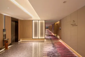 Modern hotel corridor with wooden flooring and illuminated walls.