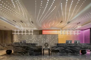 A modern hotel reception desk made of marble, featuring intricate lighting and a sleek design.