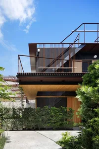 Modern building with metallic structure and greenery around it.