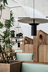 A modern restaurant interior featuring wood-paneled booths and leather seating.