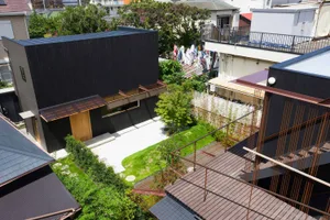 Modern house with black exterior walls, glass windows, and wooden deck.