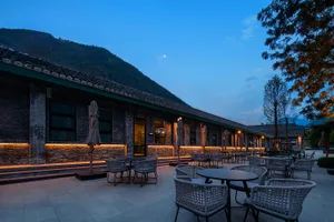 Outdoor seating area of a restaurant with brick exterior and mountain background.