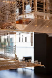 Detail of a minimalist architectural model made of glass and metal.