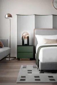 Minimalist bedroom featuring a upholstered bed with a green headboard, a matching nightstand with a globe lamp, and a texture