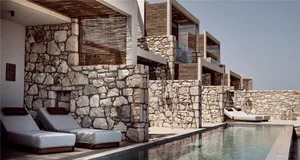 A minimalist residential exterior featuring stone and wood materials.