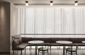 Modern cafe interior with leather cushion seating and a metal-railing bench