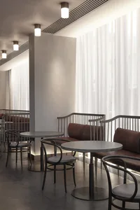 A modern cafe interior with metallic black accents and seating.