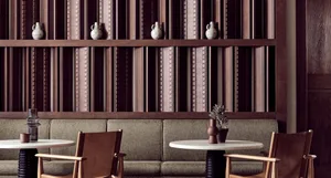 A stylish hotel bar with wooden panels, leather chairs, and decorative vases on shelves.