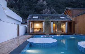 Modern hotel buildings with wooden exterior, glass walls, and concrete accents