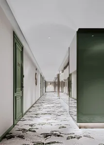 A modern hotel corridor with patterned floor tiles and green doors.